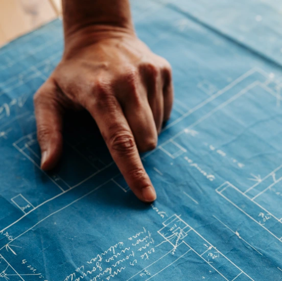 Imagen de una mano y un plano de arquitectura, que simbolizan el trabajo de Sonsonos arquitectura